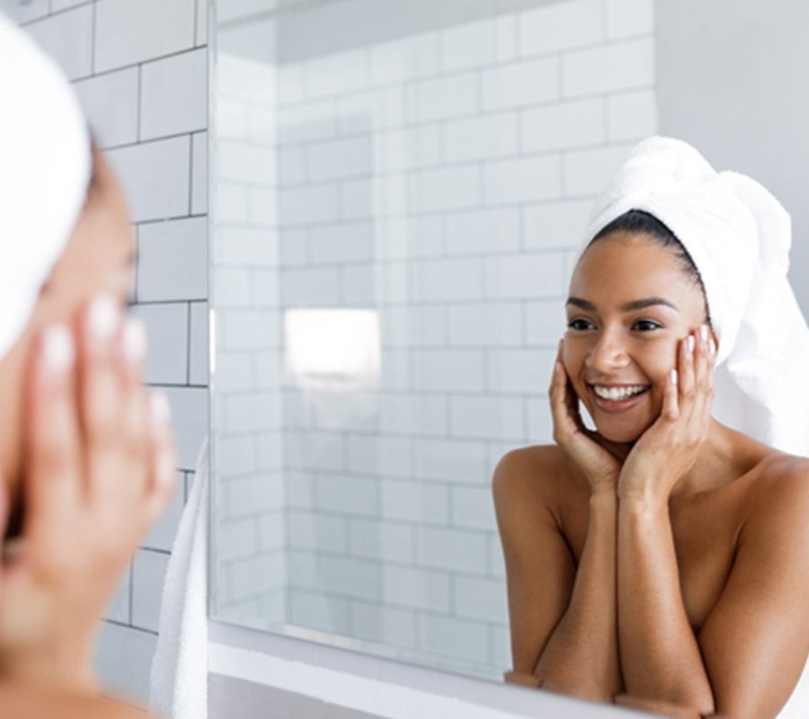 Woman looking in mirror, admiring her skin