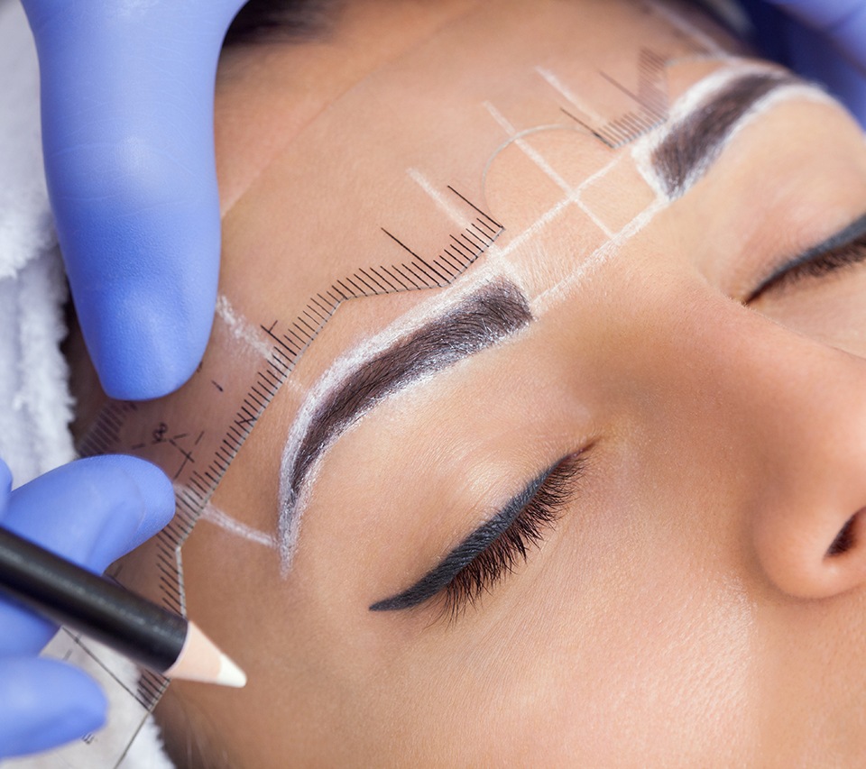 Woman relaxing while technician maps out her eyebrows for microblading