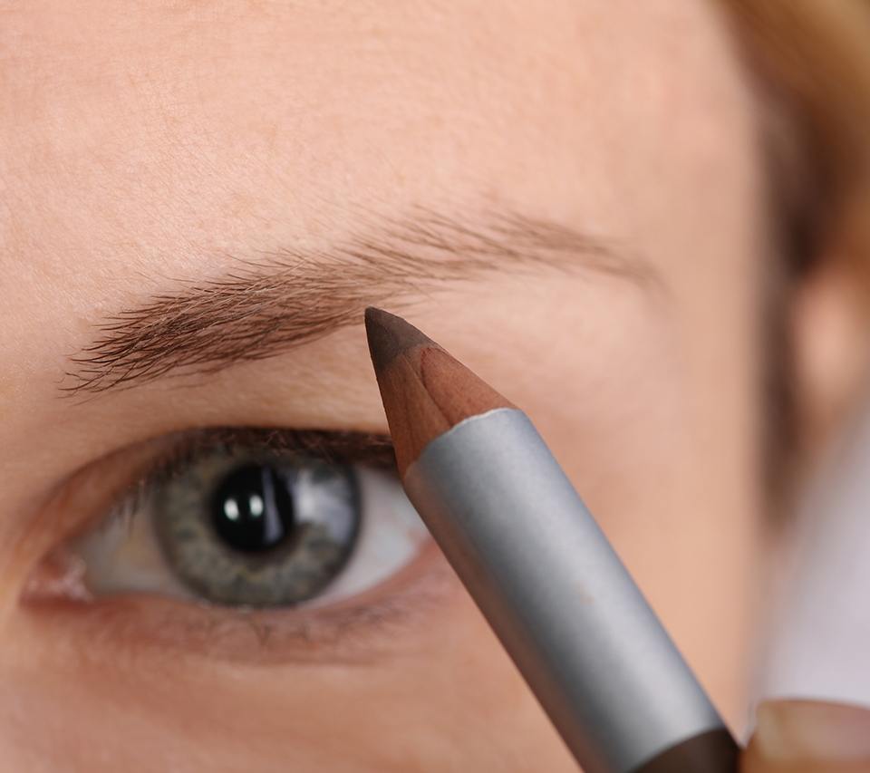 Woman using a pencil on her sparse eyebrows