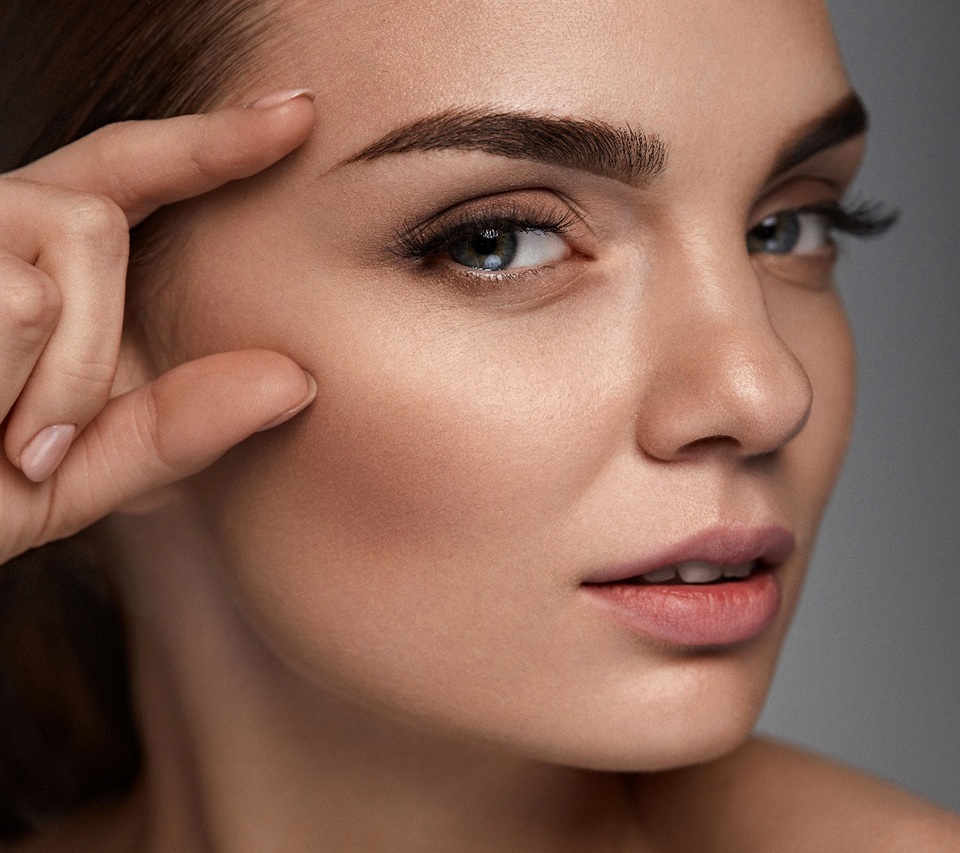 Woman showing off her beautiful, full eyebrows