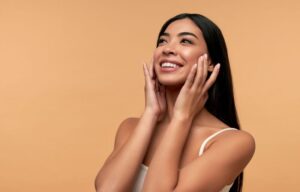 Woman with beautiful complexion touching her skin