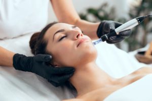 Woman relaxing during microneedling treatment